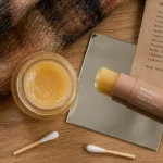Baume pour les lèvres, cire hydratante sur table en bois